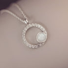 Silver necklace with a circular pendant on a soft background