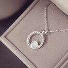 Silver necklace with a circular pendant on a soft surface