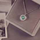 Necklace with a green gemstone pendant on a gray surface