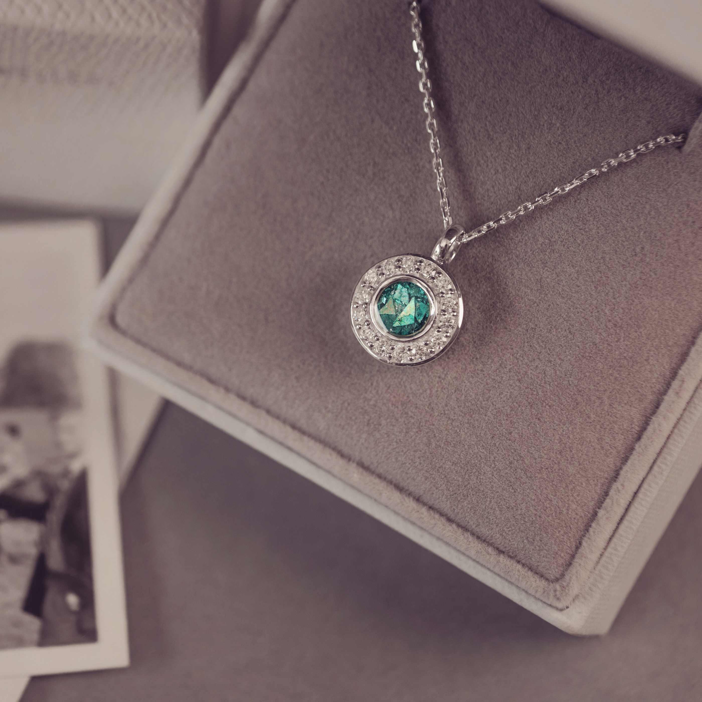 Necklace with a green gemstone pendant on a gray surface