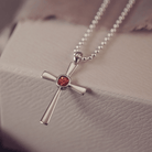silver cross necklace holding cremation ashes, resin and orange crystal
