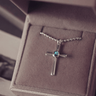 silver cross necklace holding cremation ashes, resin and turquoise crystal