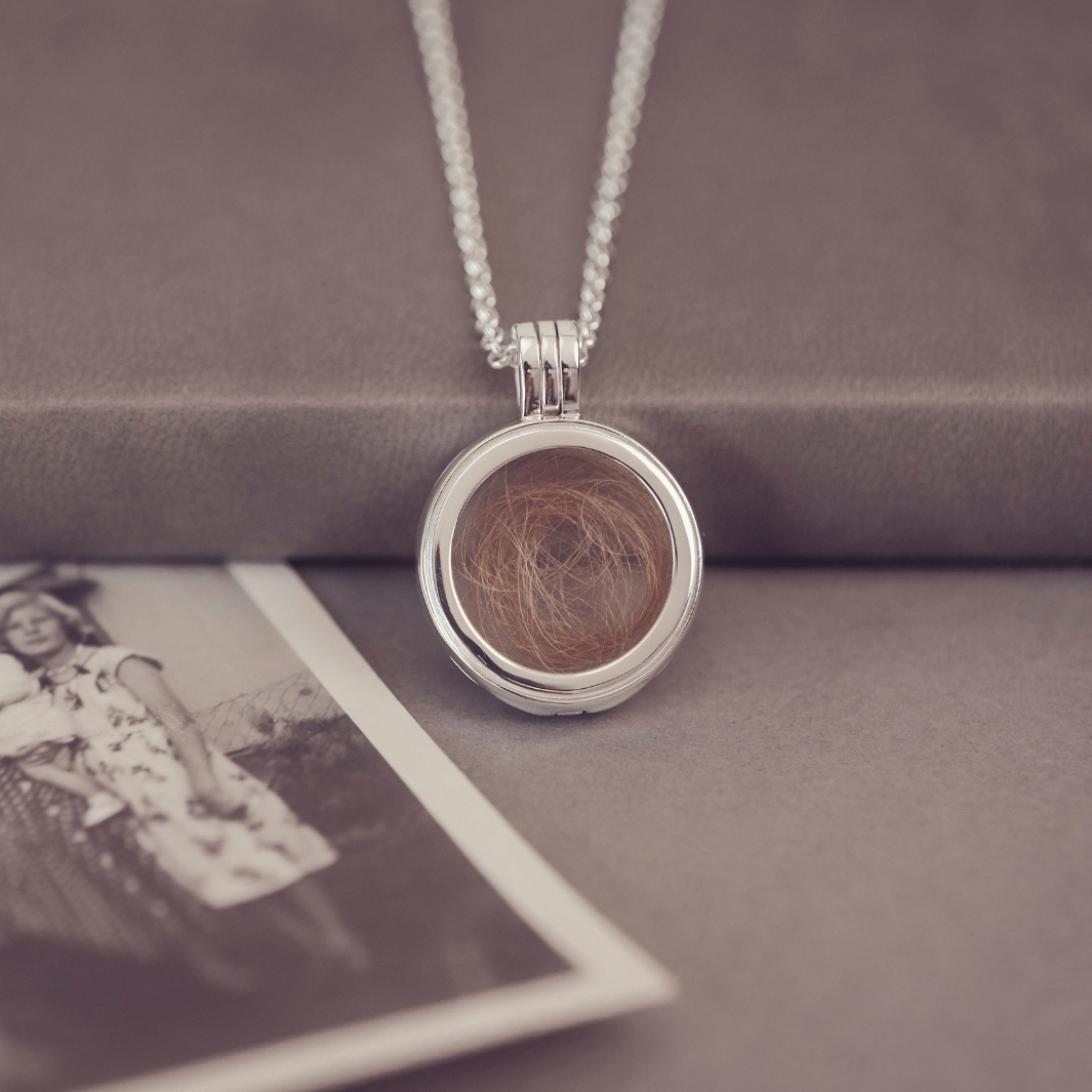 Round silver locket necklace with acrylic showing a locket of hair inside