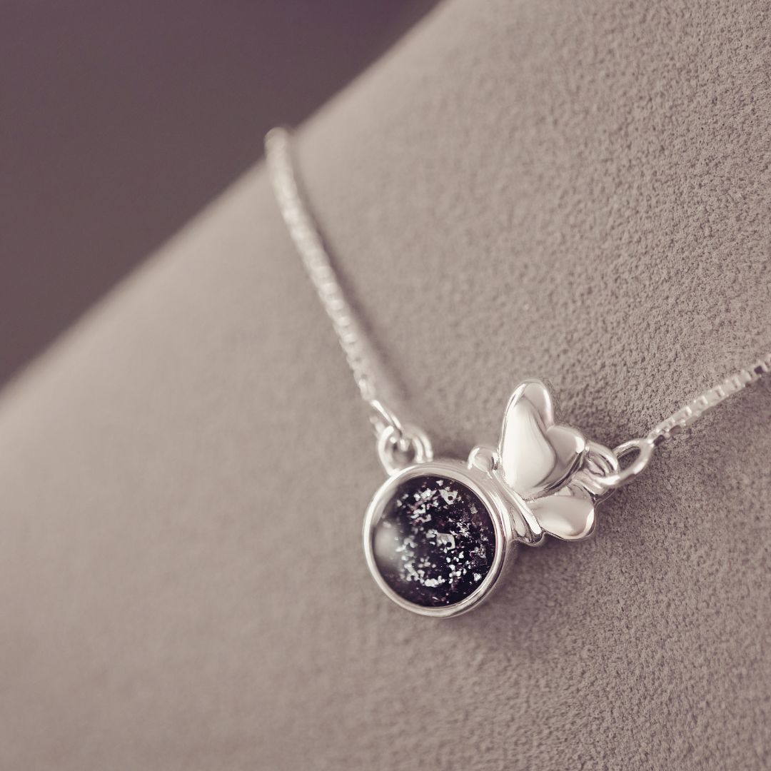 Silver necklace with a starry night pendant on a gray surface