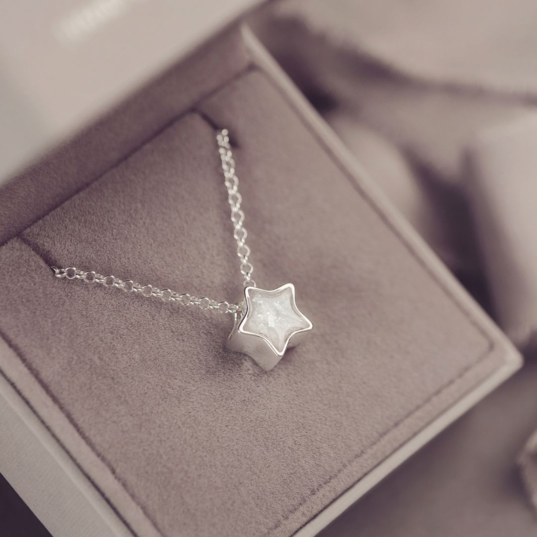 Silver star necklace on a soft gray surface