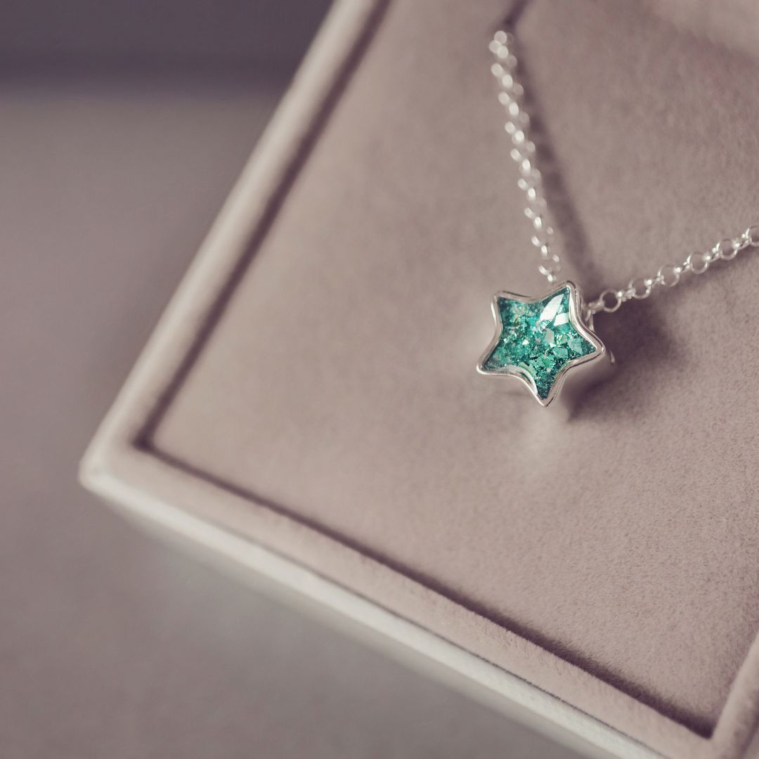 Star-shaped pendant necklace on a pink cushion