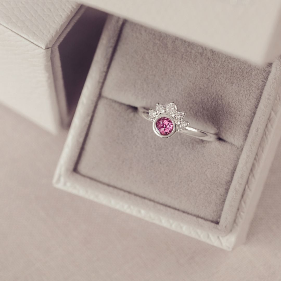 Silver ring with a pink gemstone in a jewelry box