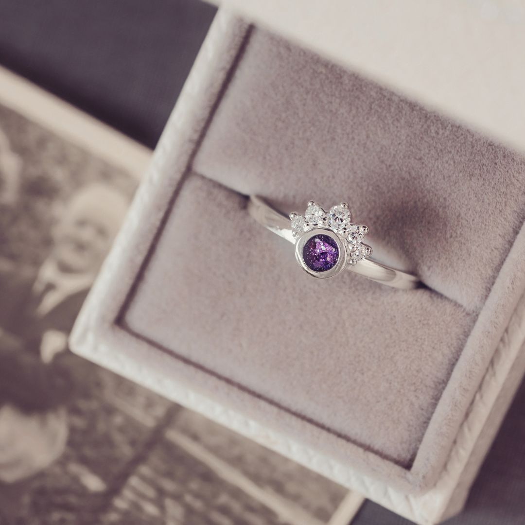 Silver ring with a purple gemstone in a jewelry box