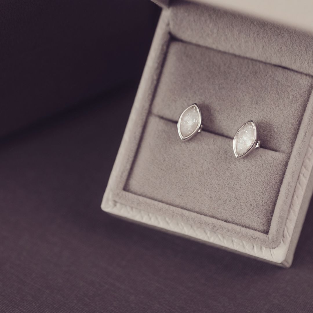 Silver earrings in a jewelry box on a dark background