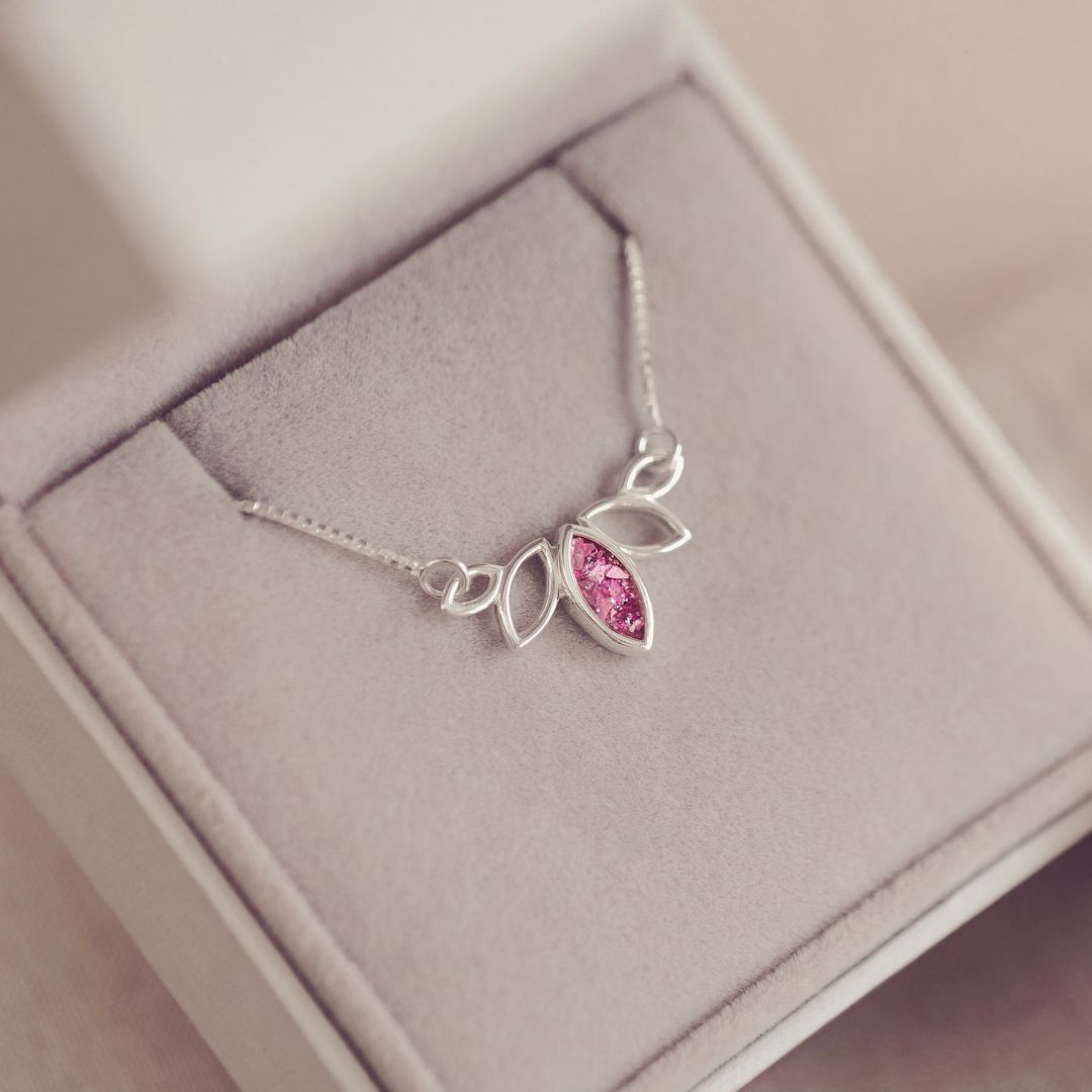 Silver necklace with a pink gemstone in a jewelry box