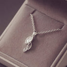 sterling silver necklace featuring gem stone, cremation ashes, clear crystal and resin laying in a grey jewellery box 