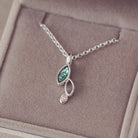 sterling silver necklace featuring gem stone, cremation ashes, green crystal and resin sat in a grey jewellery box 