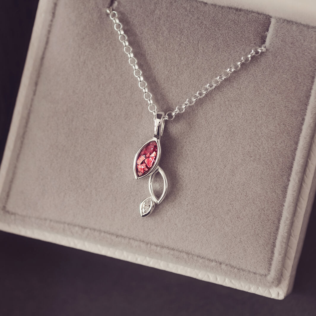 sterling silver necklace featuring gem stone, cremation ashes, red crystal and resin sat in a grey jewellery box 