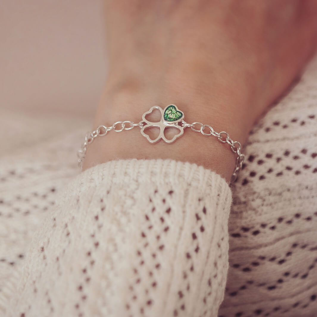 sterling silver chain bracelet with clover shaped charm holding green crystal and cremation ashes