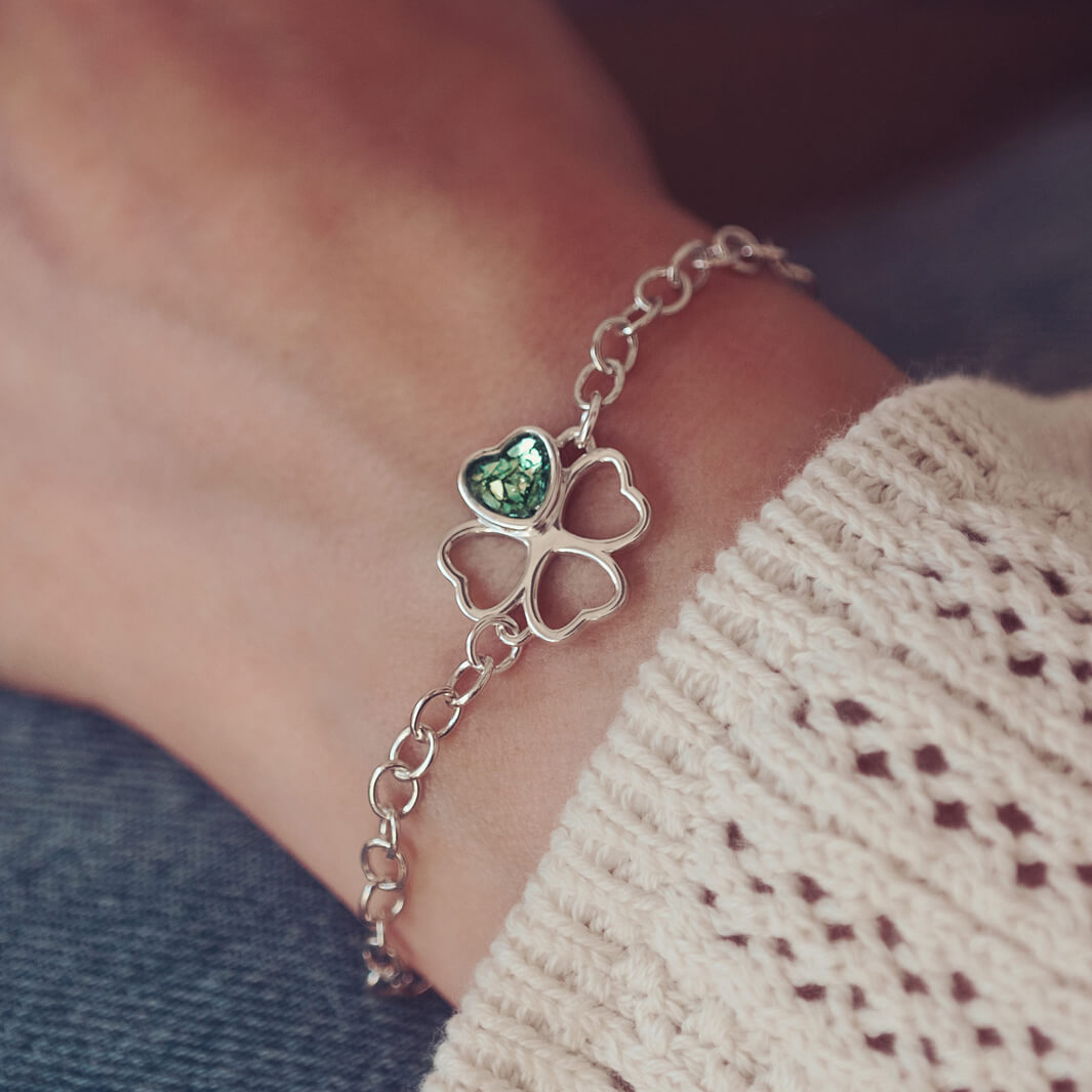 sterling silver chain bracelet with clover shaped charm holding green crystal and cremation ashes