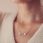 Cremation Ashes Double Infinity Heart Necklace on a silver chain, worn around a ladies neck