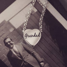 silver heart pendant on a silver chain with the message 'Grandad' engraved on the reverse