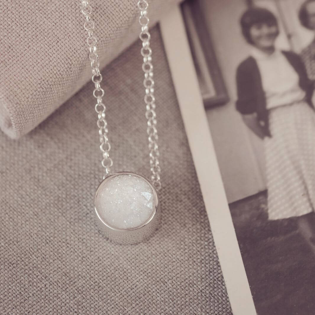 Round silver charm on silver chain, filled with clear and white crystal, glitter, resin & ashes. 
