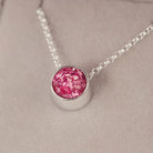 Round silver charm on silver chain, filled with pink crystal, glitter, resin & ashes. 
