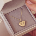 gold heart necklace filled on a gold chain, showing an engraved message of 'lots of love always x' on the reverse