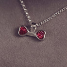 sterling silver bone shaped necklace, filled with cremation ashes, red crystal and resin.