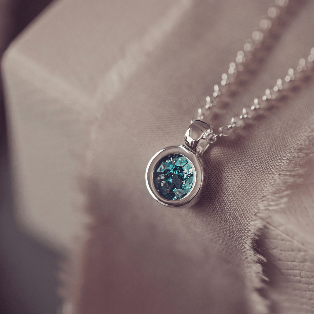 Necklace with a turquiose gemstone pendant on a soft fabric background