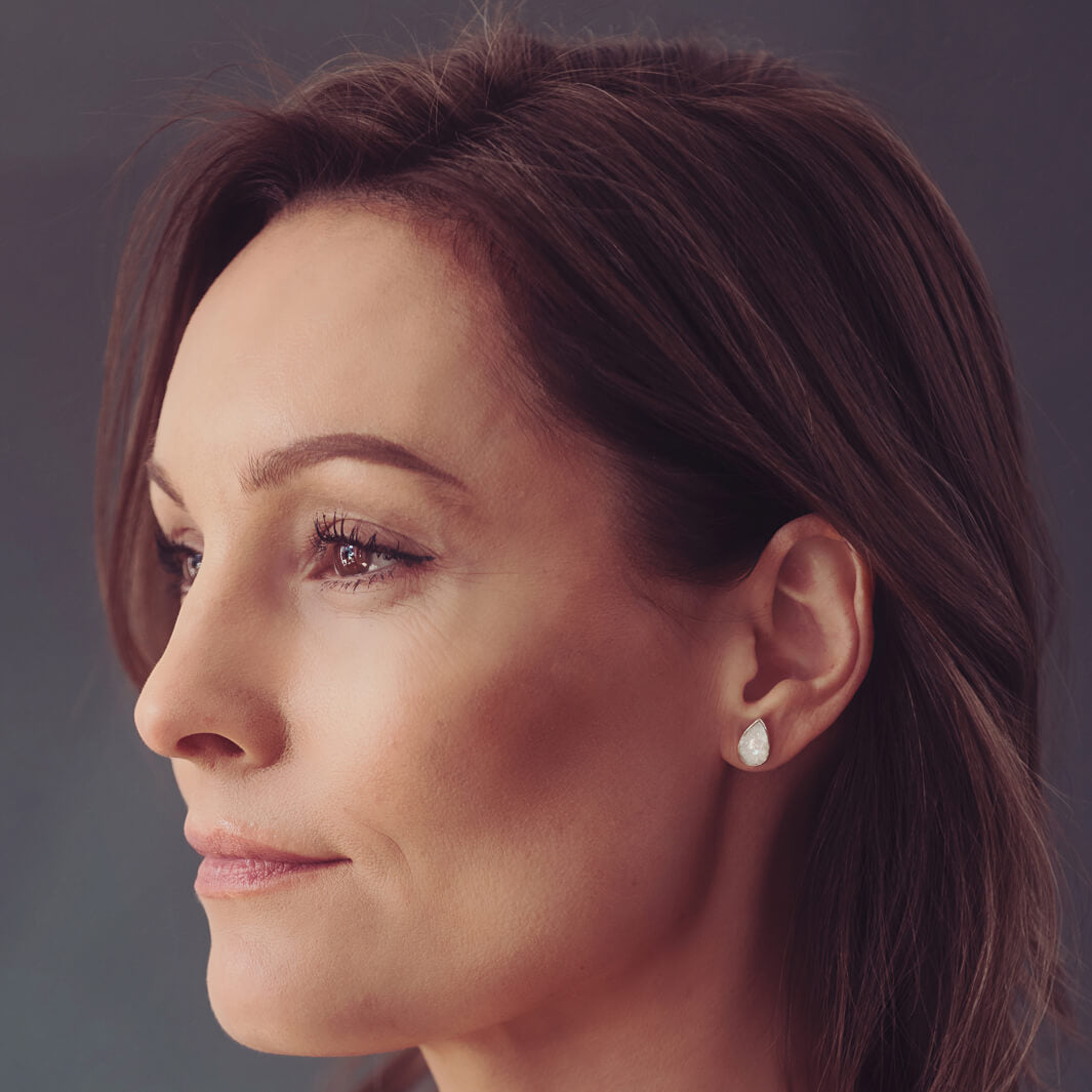 Cremation Ashes Teardrop Earrings with clear crystal, being worn in a ladies ear