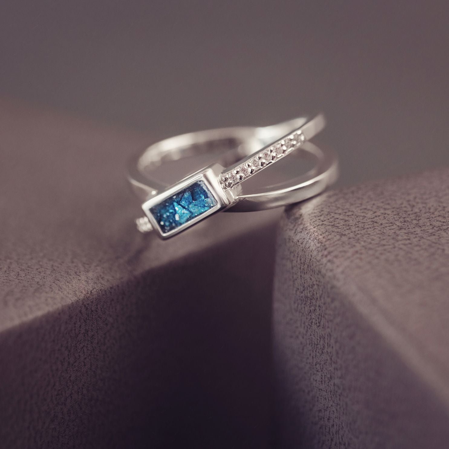 Silver ring with a blue gemstone on a textured surface