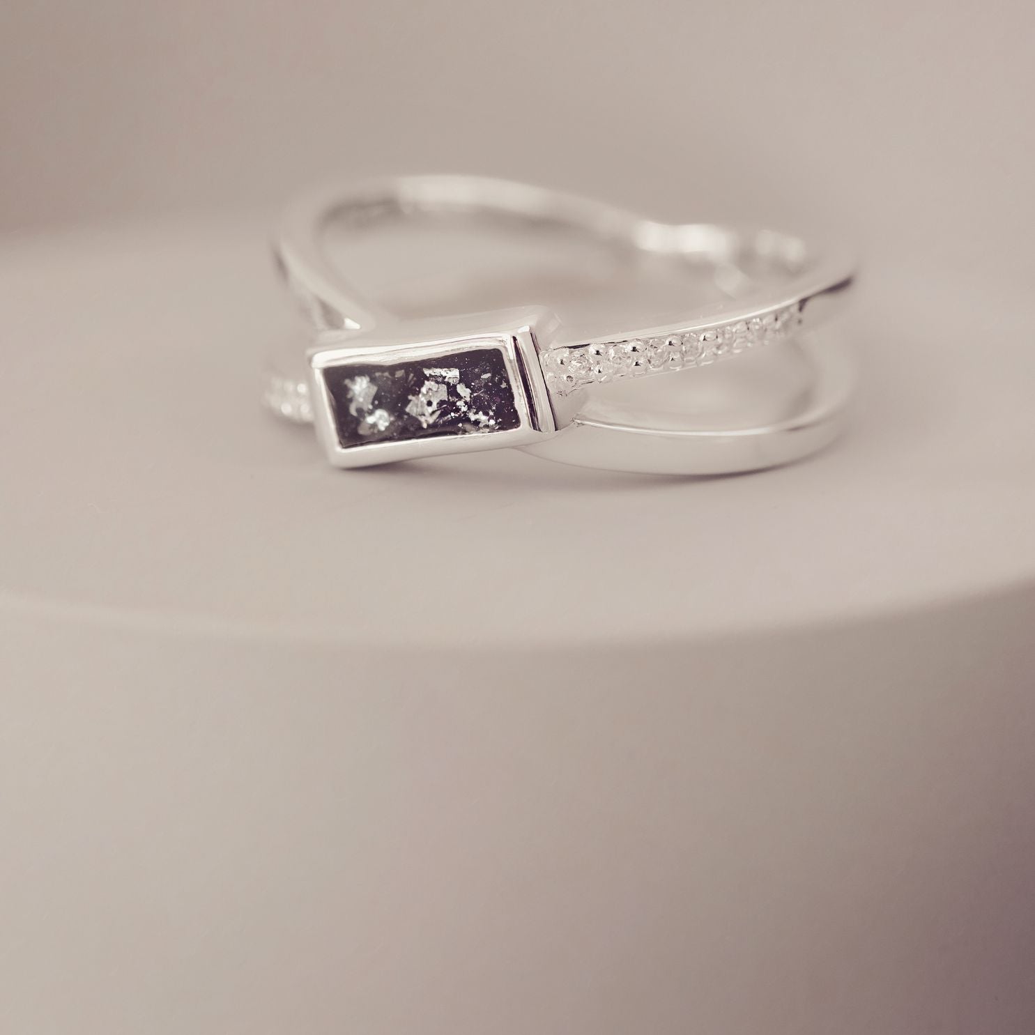 Silver ring with a rectangular design on a neutral background