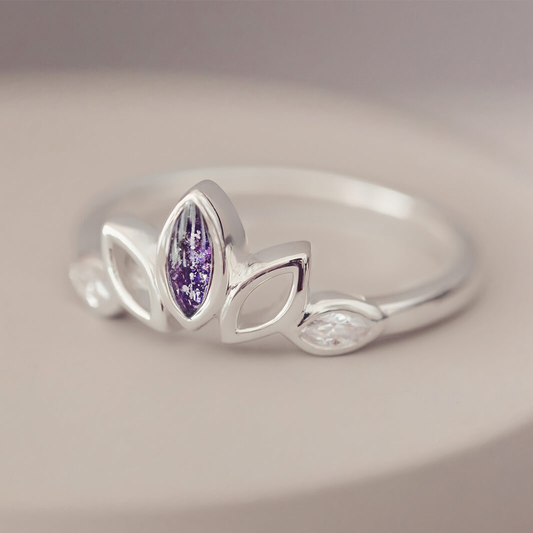 Sterling Silver Ring, created with your loved ones ashes, with Cubic Zircona gemstones. Purple floating crystals with in piece on a grey background