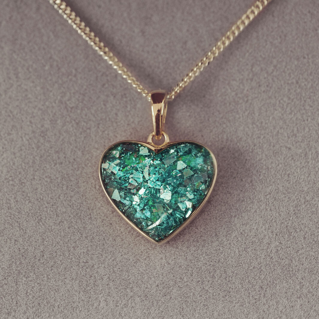 gold heart necklace filled with green crystals, resin and cremation ashes