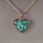 gold heart necklace filled with green crystals, resin and cremation ashes