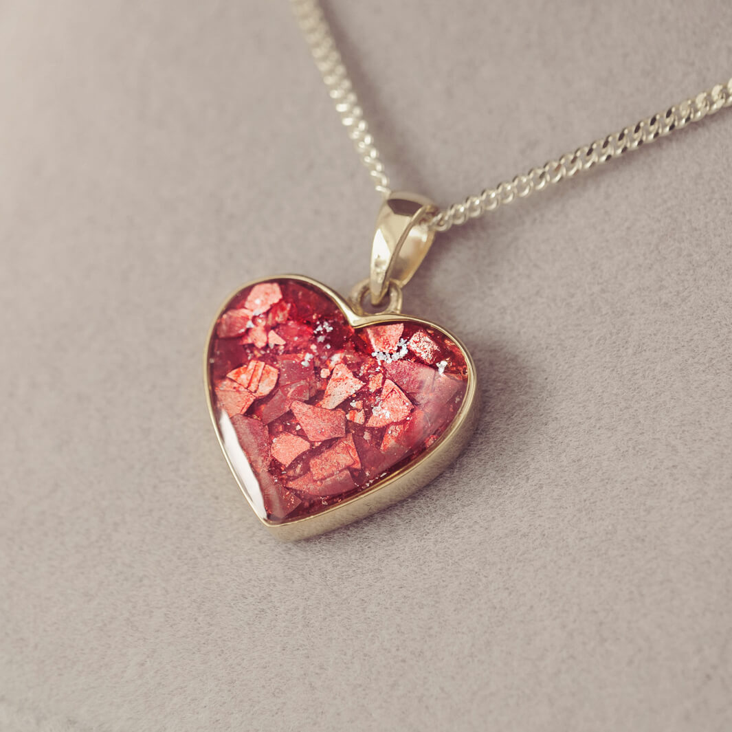 gold heart necklace filled with red crystals, resin and cremation ashes