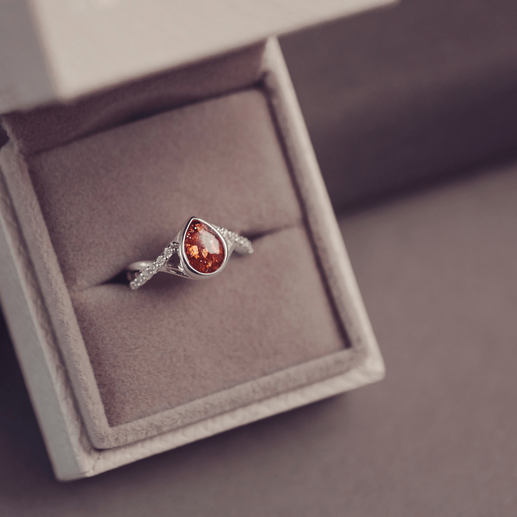 Sterling Silver Peardrop Ring with Crystals on the Band, holding cremation ashes and orange crystal