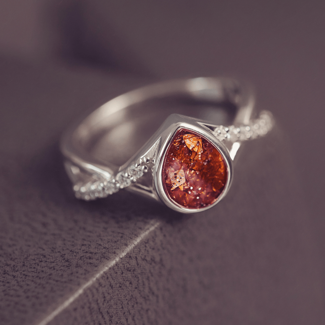 Sterling Silver Peardrop Ring with Crystals on the Band, holding cremation ashes and orange crystal