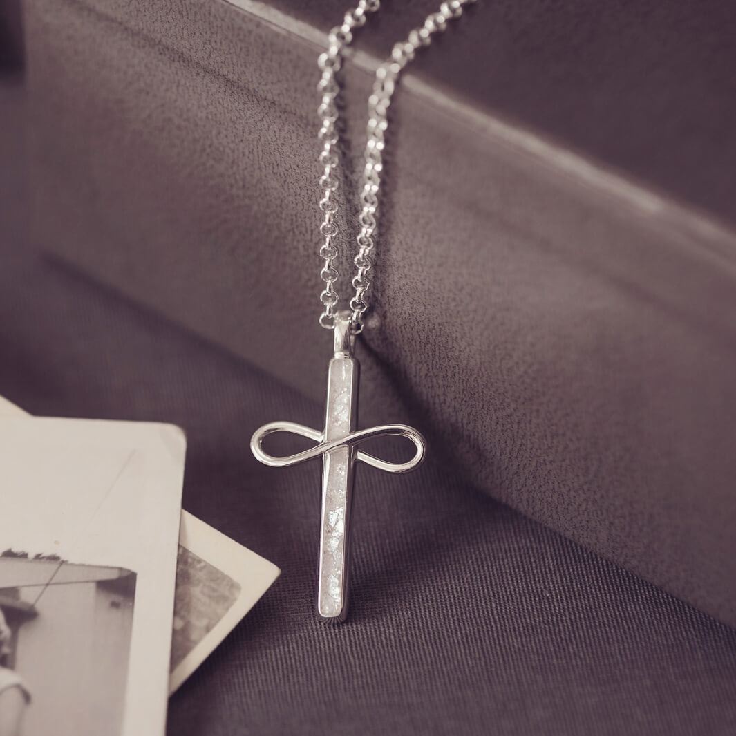 Sterling Silver Cremation Ashes Cross Necklace, filled with cremation ashes, clear crystal and resin. On a silver ball chain on a black back ground 
