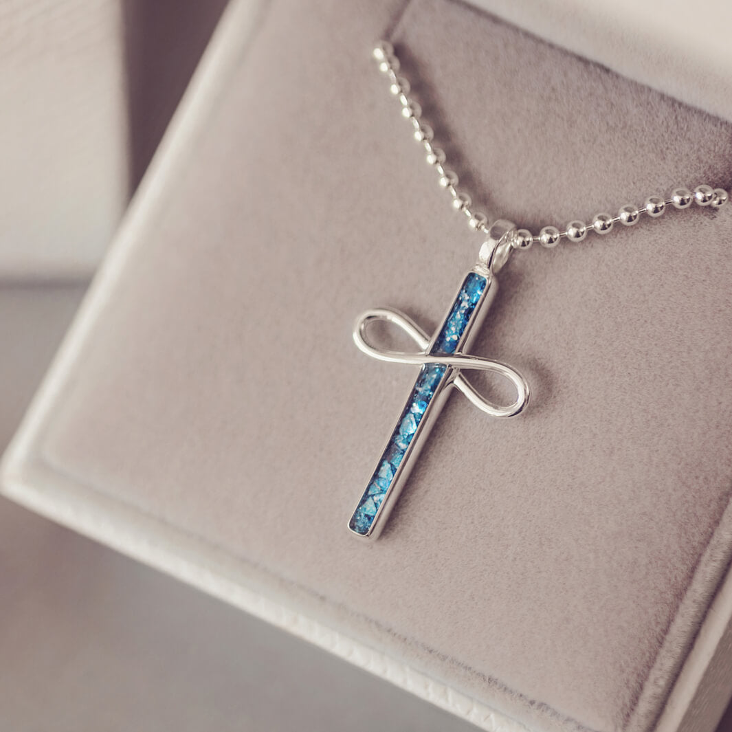 Sterling Silver Cremation Ashes Cross Necklace, filled with cremation ashes, blue crystal and resin. On a silver ball chain sat in a grey jewellery box 