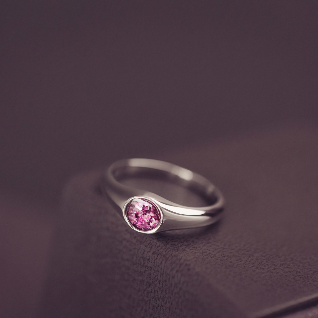 Silver ring with a pink gemstone on a dark background