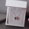 Silver ashes star necklace with purple crystals in a grey jewellery box held by a women's hand