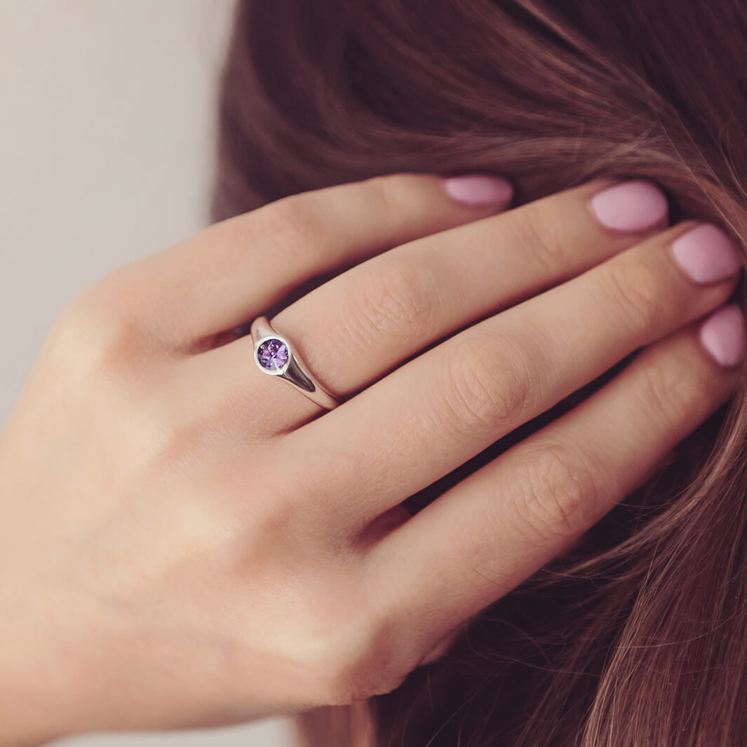 sterling silver ring band with circular stone holding cremation ashes and purple crystal